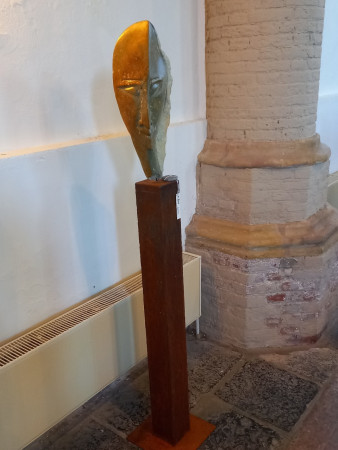 Kop van Serpentijnsteen op een sokkel van Cortenstaal